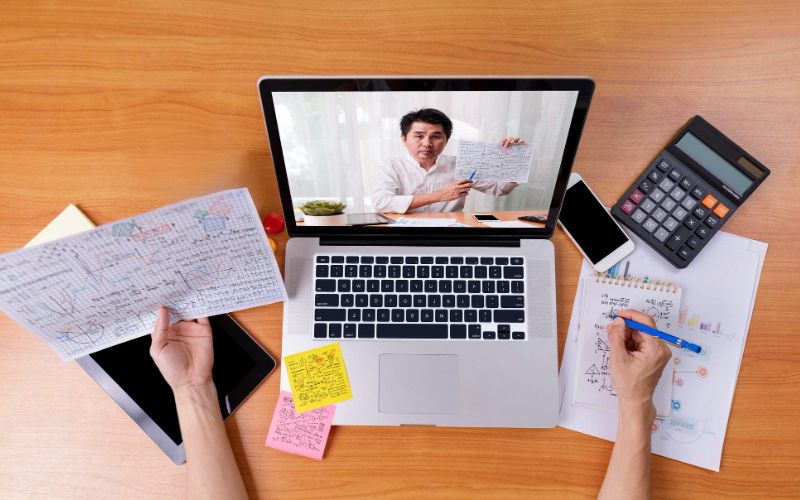 a group of professionals collaborating on a laptop and documents engaged in business activities