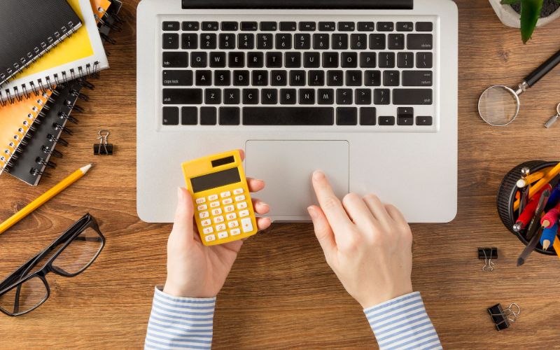 a businesswoman focused on financial calculations using a calculator to analyze financial data