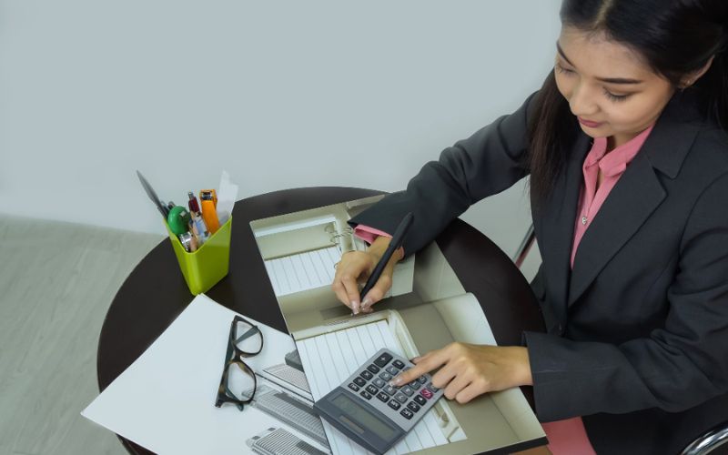 an accountant doing accounts work with calculator