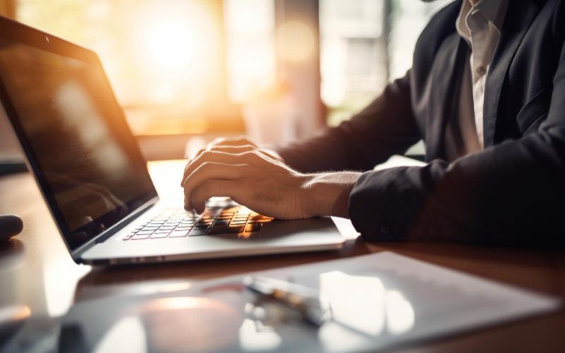 a hands on the computer and sunset behind