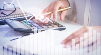 a businesswoman focused on financial calculations using a calculator to analyze financial data