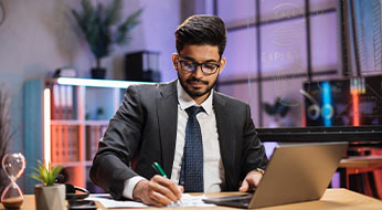 a professional man in a suit focused on his laptop, diligently working in a business setting